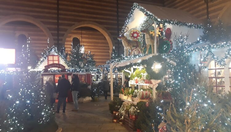 Mercatini di Natale a Verona illuminati di sera, casette con luci e decorazioni